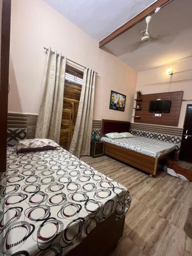 Un dormitorio con dos camas y un televisor de pantalla plana. en Sanskaar homestay, en Varanasi