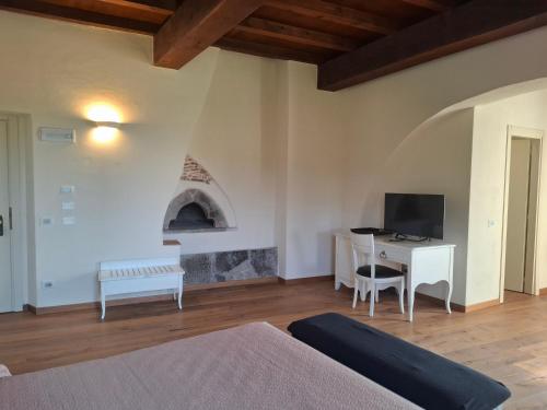 a bedroom with a bed and a desk with a television at Albergo Palazzo Costa in Beverino