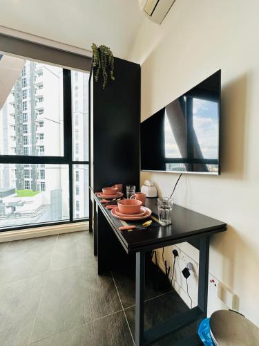 a dining room with a table with dishes on it at Scartlez suites KLCC by Dream in Gua Sai
