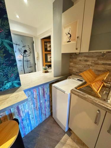 Il comprend une cuisine équipée d'une cuisinière et d'un réfrigérateur blanc. dans l'établissement Charmant Studio - Centre Cannes, à Cannes
