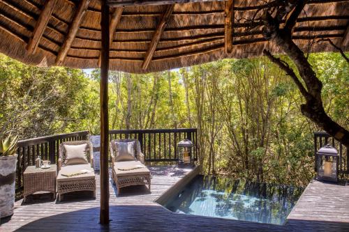 an outdoor deck with chairs and a swimming pool at Lalibela Game Reserve - Kichaka Lodge in Paterson