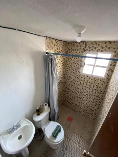 a bathroom with a sink and a toilet and a window at Studio Apartment Mariano 