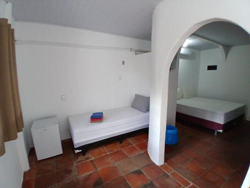 a small room with two beds and an archway at Pousada Unidos in Jijoca de Jericoacoara