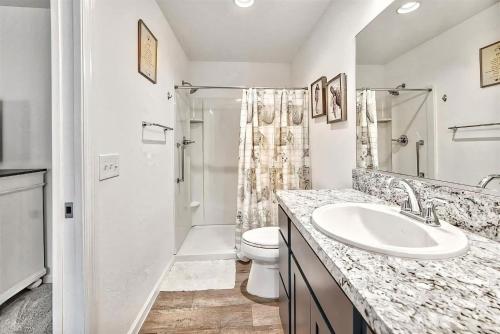a white bathroom with a sink and a toilet at King Sized Comfort in The Village of Deluna in The Villages