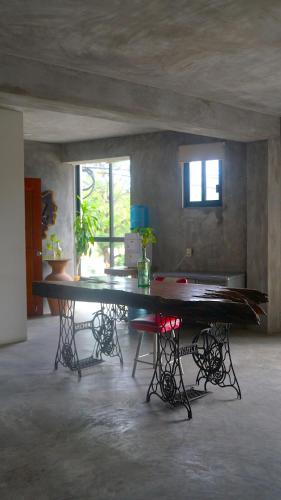 a large table in a room with two windows at Madre Tierra Hostal in Puerto Escondido