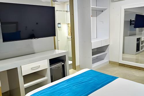 a living room with a tv and a large screen at Hotel Lotto Boutique in Cali