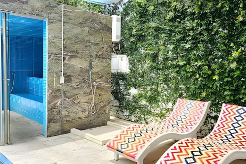 a bathroom with a shower and a bench in front of a wall at Hotel Lotto Boutique in Cali