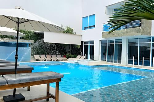 a swimming pool with an umbrella next to a building at Hotel Lotto Boutique in Cali