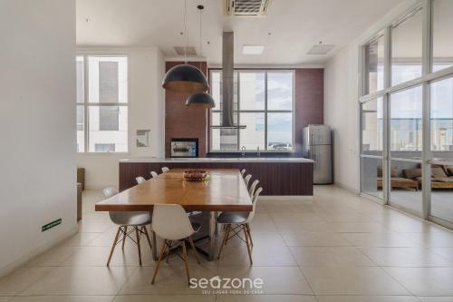 a kitchen and dining room with a wooden table and chairs at Edifício Metropolitan Barcelona - Jardim Goias - MBC in Goiânia