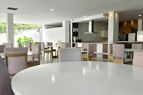 a dining room with a white table and chairs at Hotel Lotto Boutique in Cali