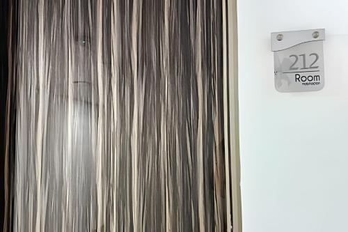 a door with a room sign next to a curtain at Hotel Lotto Boutique in Cali