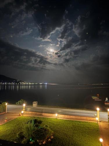 a view of the water at night with the moon at Τηλεμαχος Apartments in Loutra Edipsou
