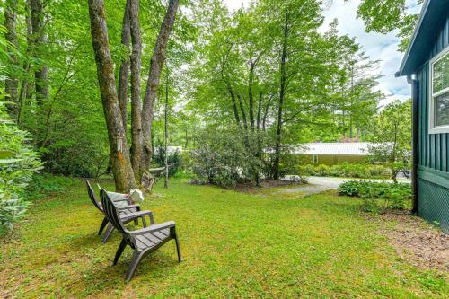 two benches sitting in the grass next to a house at Highlands Vacation Rental - Walk to Main St! in Highlands