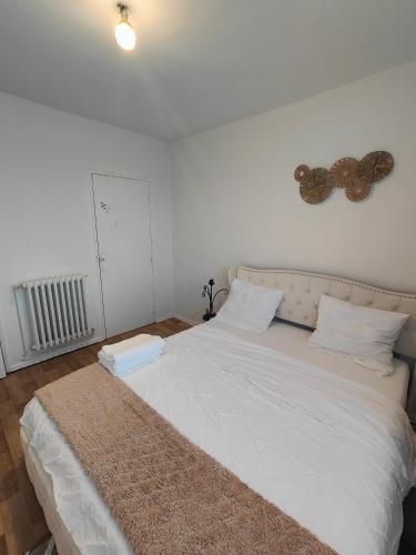 une chambre avec un grand lit blanc avec des draps blancs dans l'établissement Chambre privée à Triolo - Stade - Fac Lille 1, à Villeneuve d'Ascq