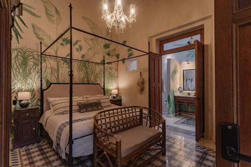 a bedroom with a canopy bed and a chair at Casa Esther - Parque Santiago in Mérida