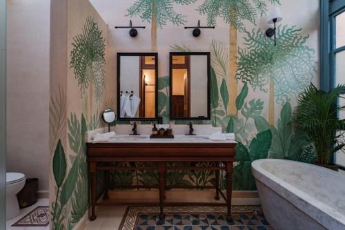 a bathroom with a sink and a mirror and a tub at Casa Esther - Parque Santiago in Mérida