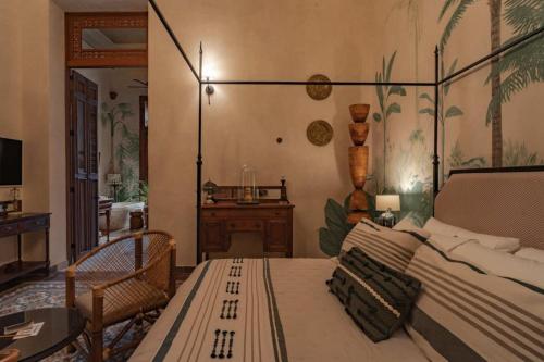 a bedroom with a bed and a desk in it at Casa Esther - Parque Santiago in Mérida