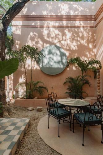 a patio with a table and chairs in a courtyard at Casa Esther - Parque Santiago in Mérida