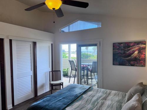 a bedroom with a bed with a ceiling fan at Pines182 in Kailua-Kona