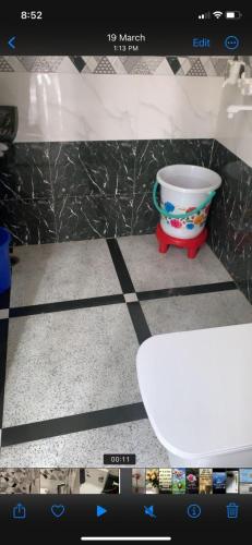 a bathroom with a white toilet and a bowl at AK family Home Stay in Gaushala