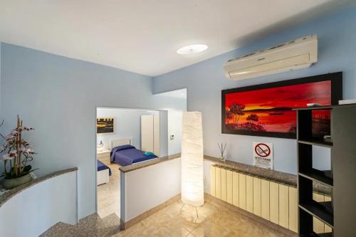a living room with a blue wall with a large tv at Appartamento in centro 65mq x 4 persone in Trino