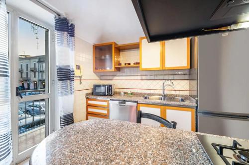 a kitchen with a counter top and a table at Appartamento in centro 65mq x 4 persone in Trino