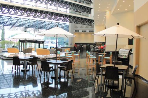 a restaurant with tables and chairs and umbrellas at Holiday Inn Mexico Dali Airport by IHG in Mexico City