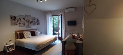 een slaapkamer met een bed, een bureau en een raam bij "LAGO VERDE" Como garage privato in Como