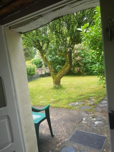 an open door with a blue chair in a yard at KerJean in Caurel