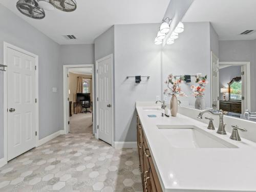 a bathroom with two sinks and a large mirror at The Sapphire Sanctuary with Pool in Allen