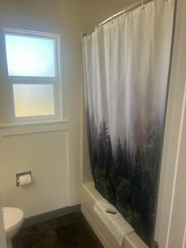 a bathroom with a shower curtain and a toilet at El Rancho Motel in Williams