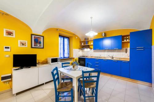 a kitchen with blue cabinets and a table and chairs at Ampio Bilocale (in centro) 60 mq 3-4 Pers. in Trino