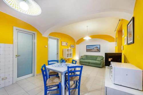a dining room with yellow walls and a table and chairs at Ampio Bilocale (in centro) 60 mq 3-4 Pers. in Trino