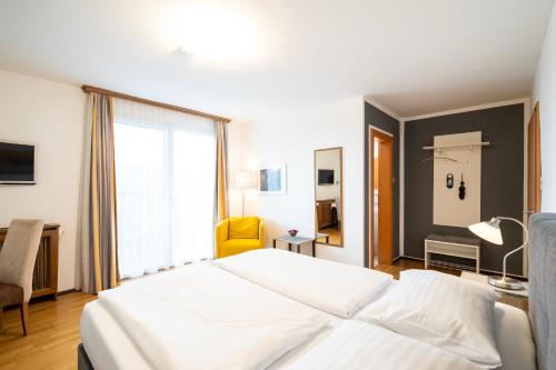 a bedroom with a large white bed and a window at Erlebnishaus Spiess in Feldkirchen in Kärnten