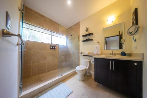 a bathroom with a shower and a toilet and a sink at The Cove Door 15 and 16 Upper & Lower Unit in Ocotal