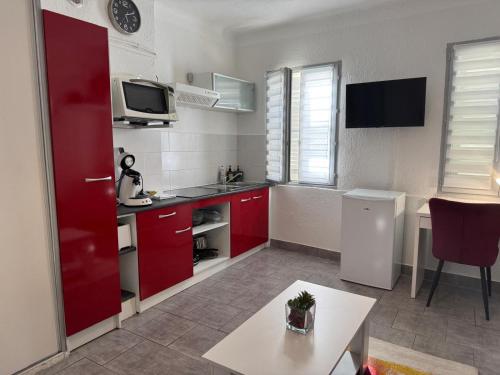 Elle comprend une petite cuisine avec des placards rouges et un réfrigérateur rouge. dans l'établissement Studio 2 personnes dans le célèbre quartier des chartreux, à Marseille
