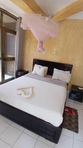 a bedroom with a large white bed with two towels on it at Dagmaros Guest House in Bahir Dar