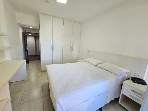 a bedroom with a white bed and a white cabinet at ABC Apart Hotel in Brasilia
