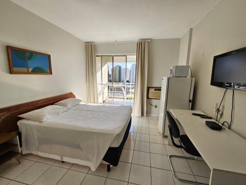 a hotel room with a bed and a desk and a television at ABC Apart Hotel in Brasilia