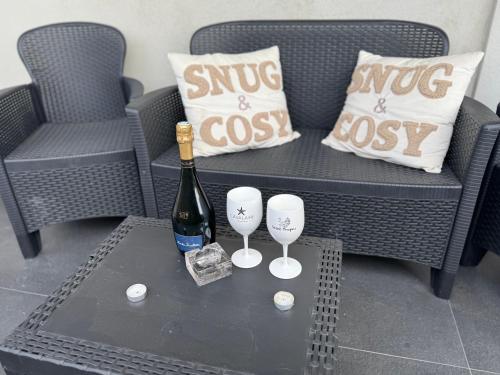 a bottle of wine and two wine glasses on a table at Villa Hirondelles 35 in Cavalaire-sur-Mer