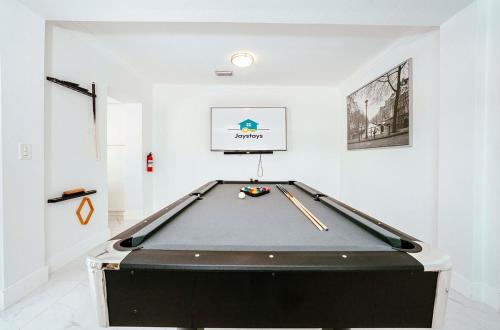 a pool table in a white room with a billiard at Luxe 4 BR Heated Pool - Hardrock - Stadium - Beach in Hollywood