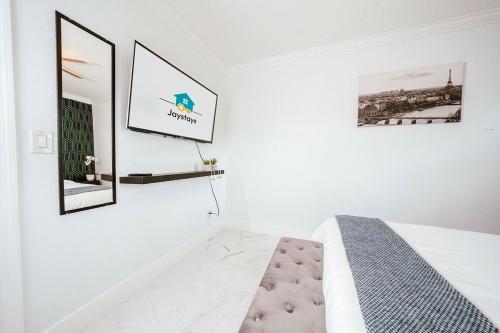 a white bedroom with a bed and a mirror at Luxe 4 BR Heated Pool - Hardrock - Stadium - Beach in Hollywood