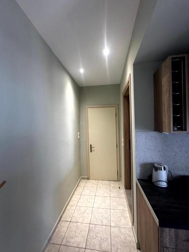 a kitchen with a door and a tile floor at Andreas Studios in Mastichari