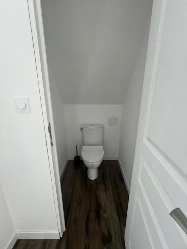 une salle de bain avec des toilettes blanches dans une chambre dans l'établissement Maison de campagne, à Ploëzal