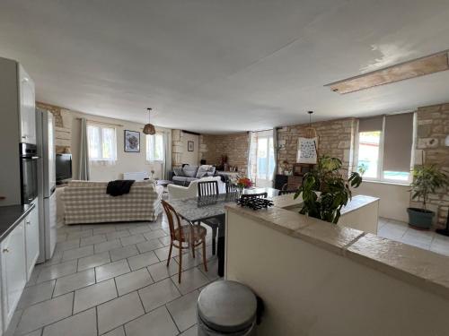 un grand salon avec une cuisine et un salon dans l'établissement Gîte de l'hortensia-Charmante maison de campagne au calme, à Gourville