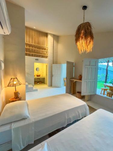 a bedroom with two beds and a chandelier at KANAHA BEACH VILLA in Icaraí