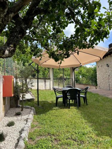 a table and chairs under an umbrella in the grass at Agriturismo Castelfranco - appartamenti Norcia in Norcia