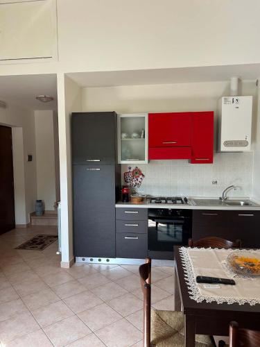 a kitchen with red cabinets and a table at Agriturismo Castelfranco - appartamenti Norcia in Norcia