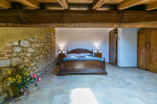 a bedroom with a bed and a stone wall at Podere La Querciola in Guardistallo