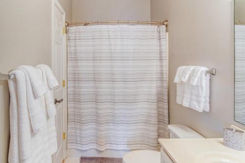uma casa de banho com um chuveiro e toalhas brancas em 1 Mi to Beach Family Condo in North Myrtle Beach! em Myrtle Beach